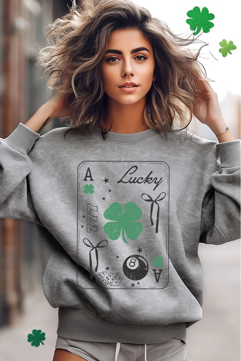 Woman wearing a gray sweatshirt with a four-leaf clover design and text.