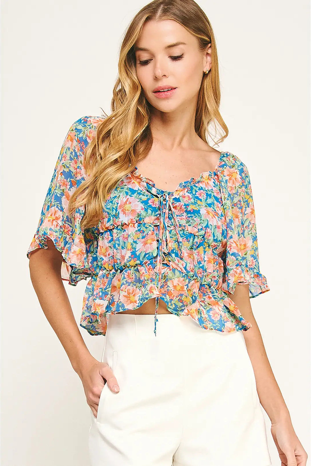 Woman wearing a colorful floral blouse with a white background