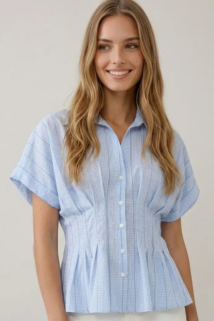 Woman wearing a blue checkered shirt against a plain background