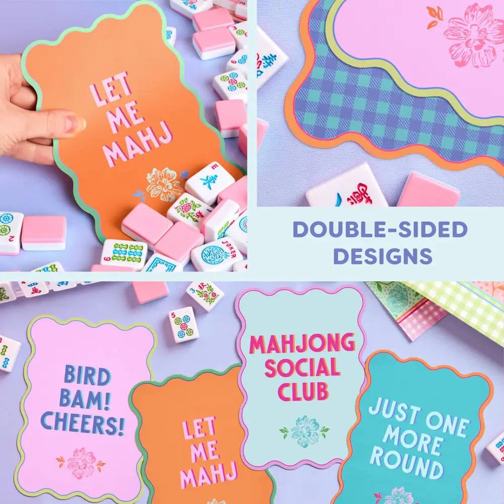 A collage showing colorful double-sided mahjong tile backings and matching tile pieces. A hand holds an orange tile with the words “LET ME MAHJ,” and other visible tile designs include pink, blue, green, and white with floral, plaid, and text graphics.