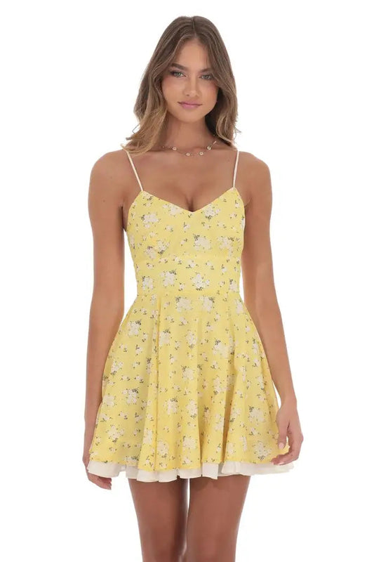 Woman wearing a yellow floral dress on a white background