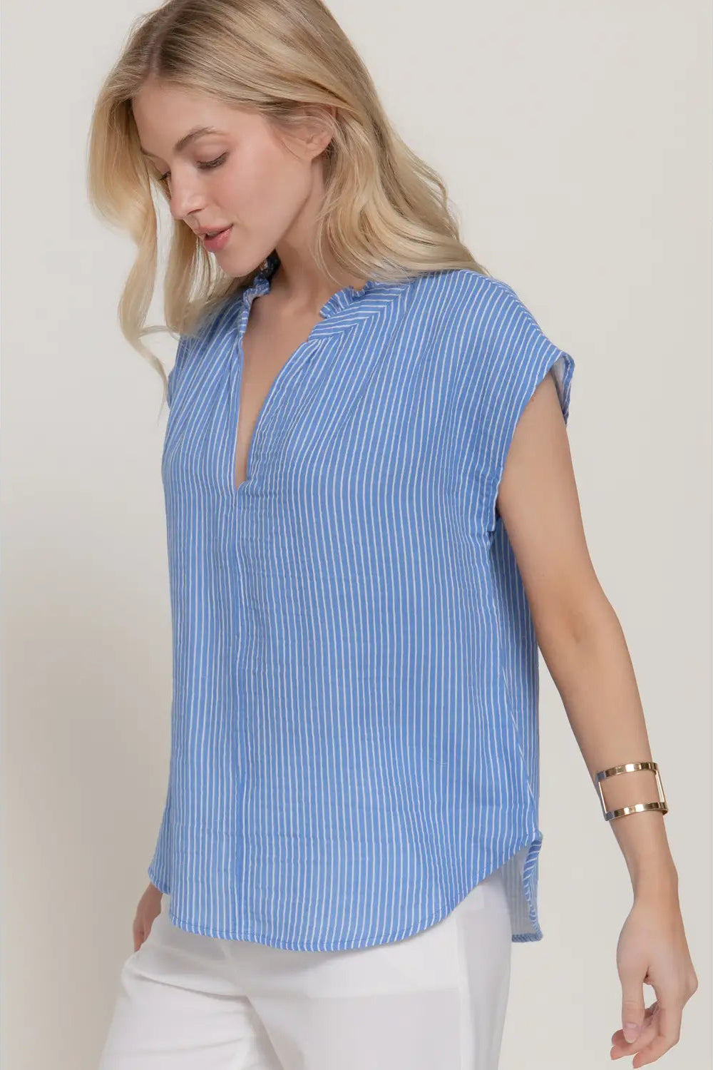 Woman wearing a blue striped shirt against a plain background