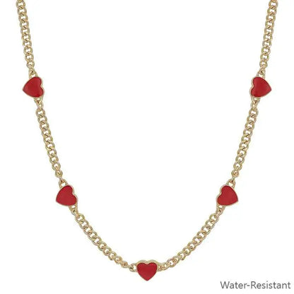 Gold necklace with red heart charms on a white background