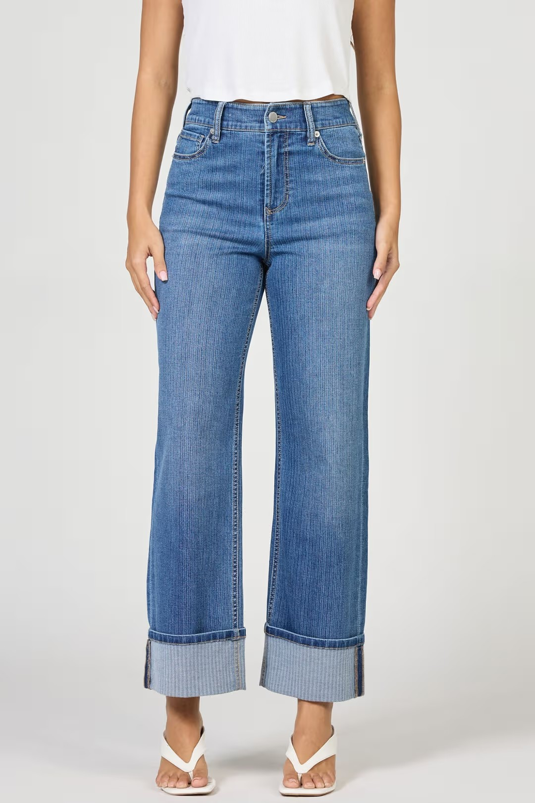 Blue jeans worn by a person on a white background