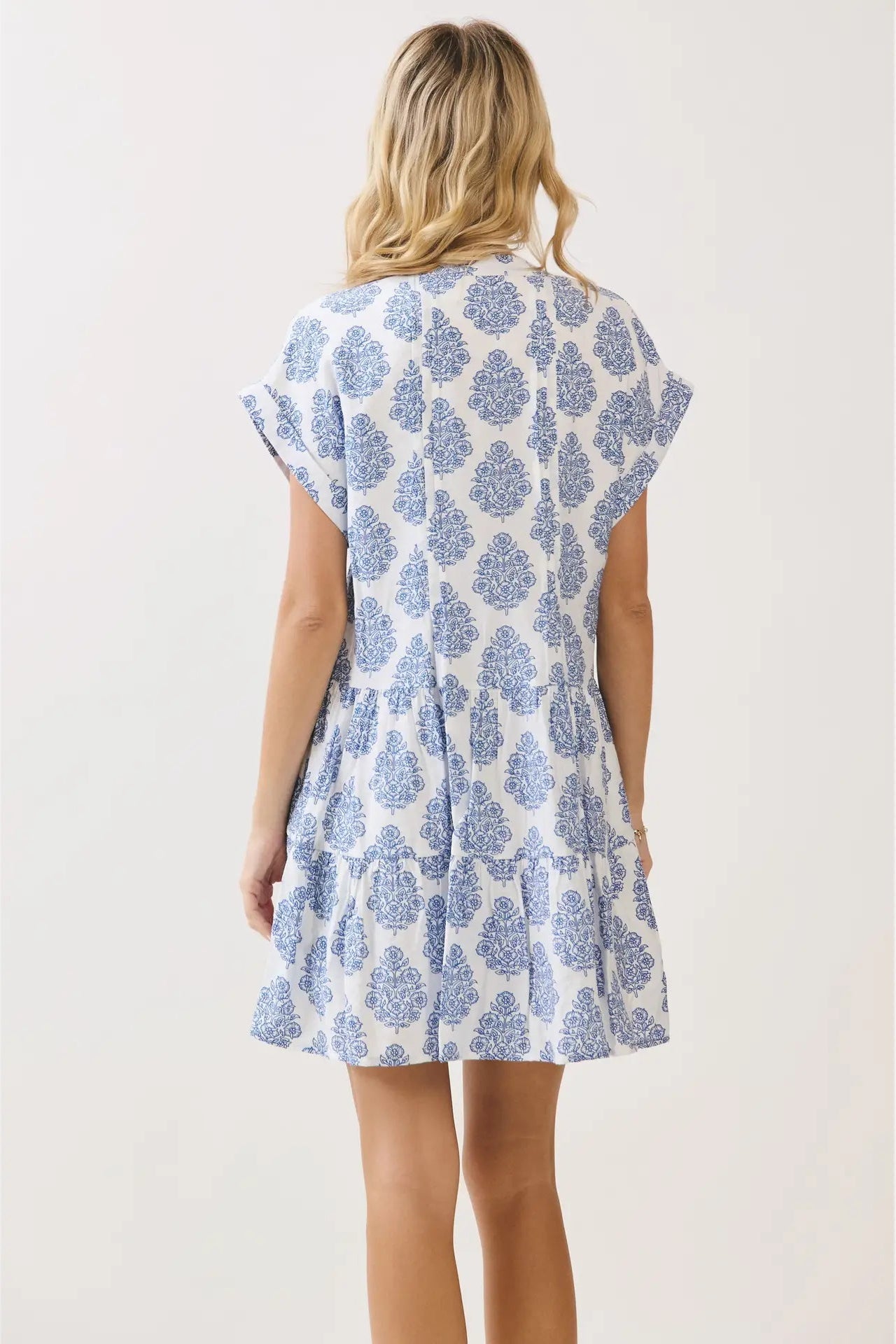 Woman wearing a blue floral dress on a white background