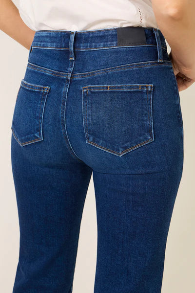 Blue jeans worn by a person on a plain background