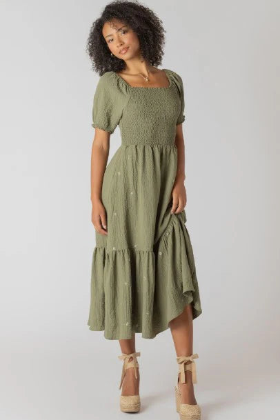 Woman wearing a green dress with a plain background