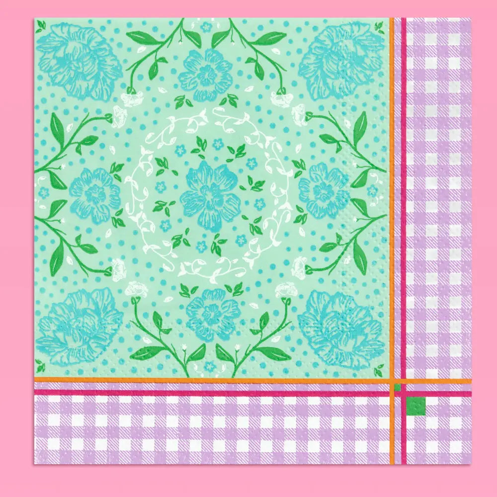 A square decorative paper napkin featuring a mint green floral pattern with blue flowers, green leaves, and white dots, finished with a lavender-and-white gingham border and thin orange and magenta stripes.