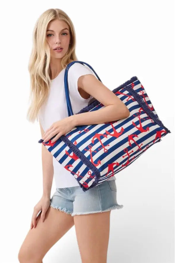 Woman holding a nautical-themed tote bag with red anchors on a white background