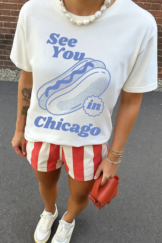 Person wearing a white t-shirt with 'See You in Chicago' text and graphics, red and white striped shorts, and white sneakers.