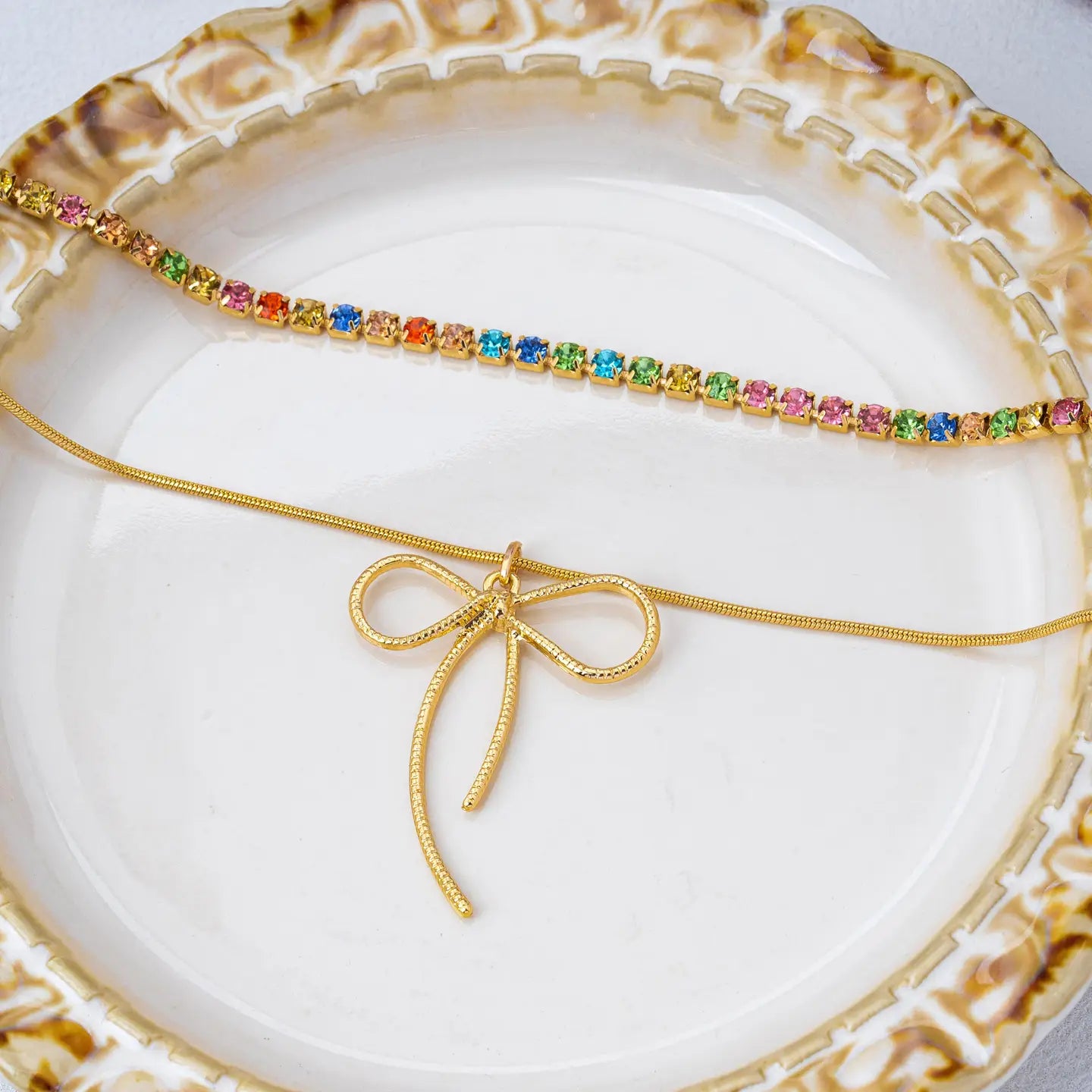 Gold jewelry with colorful stones on a decorative plate
