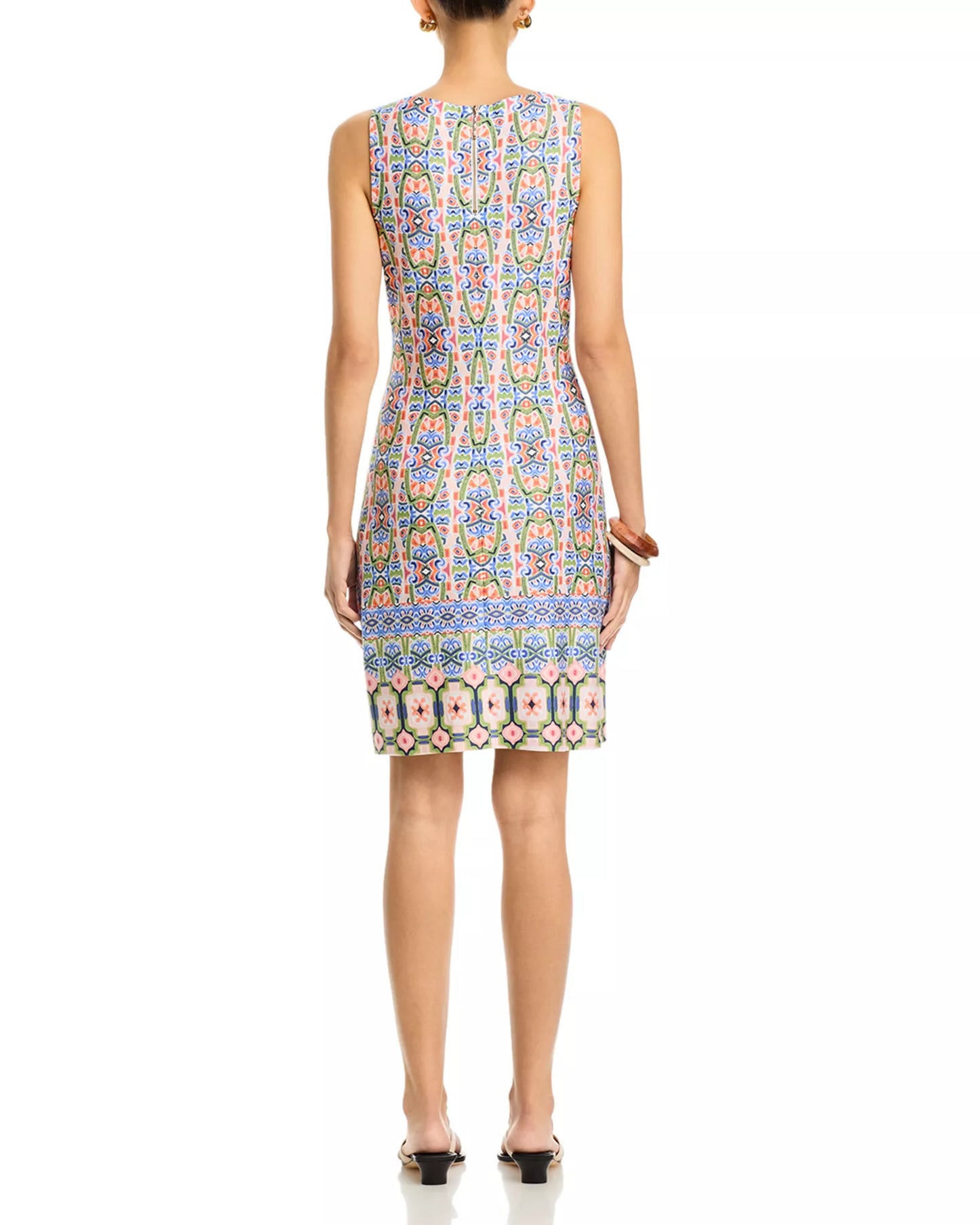 Woman wearing a sleeveless dress with a colorful pattern on a white background
