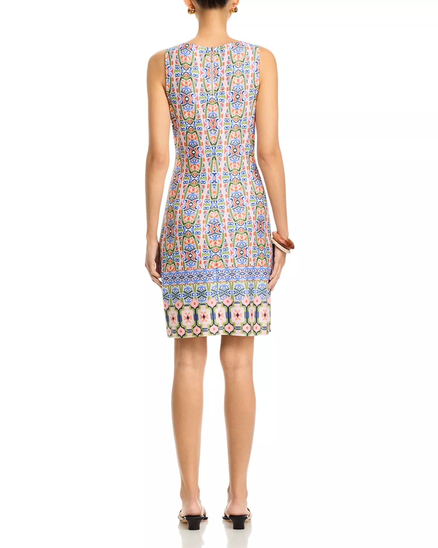 Woman wearing a sleeveless dress with a colorful pattern on a white background