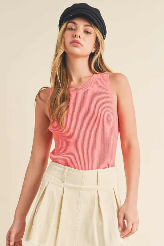 Woman wearing a pink ribbed tank top and beige skirt on a beige background