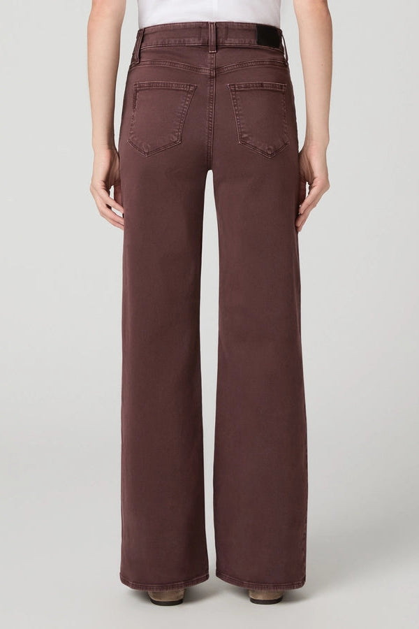 A person shown from the back wearing high-waisted, wide-leg brown pants against a light gray studio background.