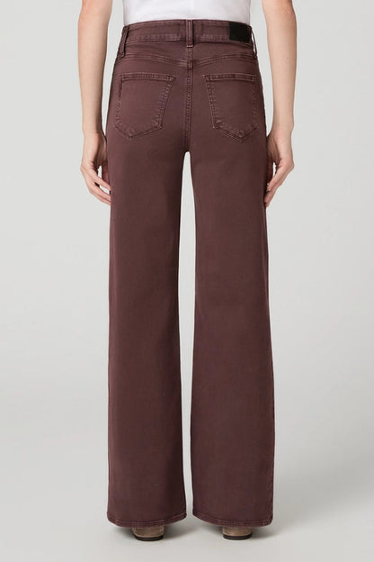 A person shown from the back wearing high-waisted, wide-leg brown pants against a light gray studio background.
