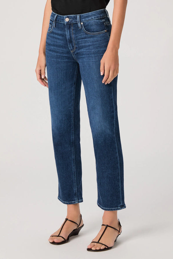 Person wearing blue jeans on a plain background