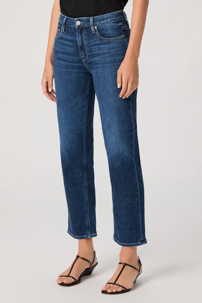 Person wearing blue jeans on a plain background