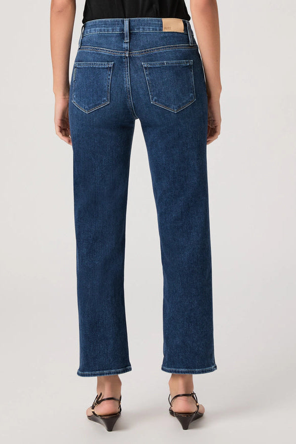 Person wearing blue jeans on a plain background