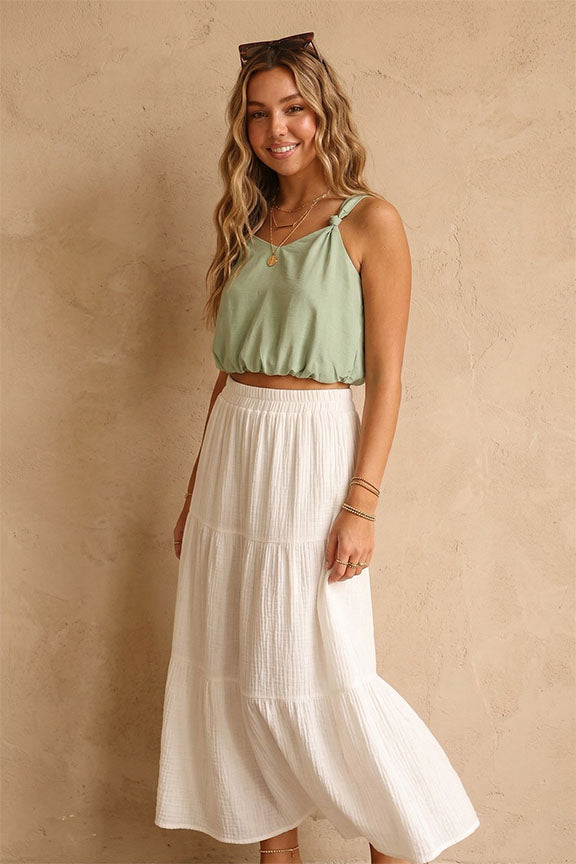 woman wearing green tank with white bottoms
