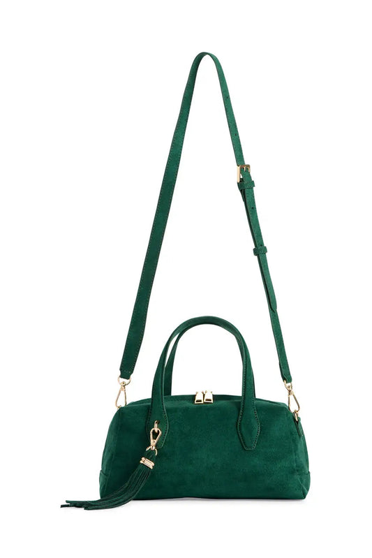 A dark green suede handbag with a matching shoulder strap, gold-tone hardware, and a tassel detail, shown against a plain white background.