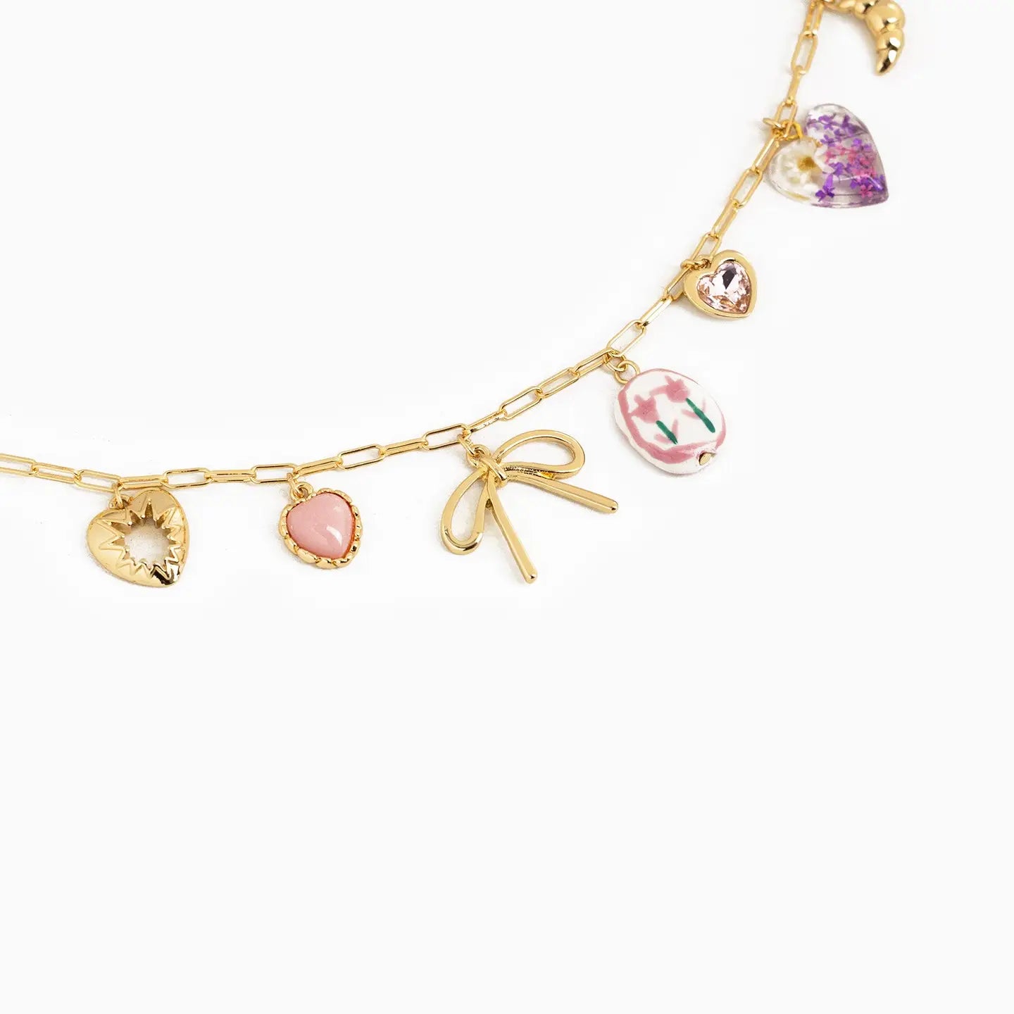 Gold charm bracelet with various charms on a white background