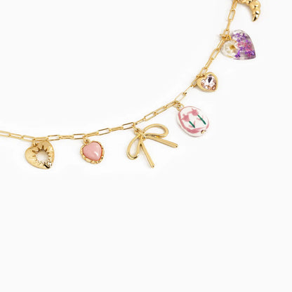 Gold charm bracelet with various charms on a white background