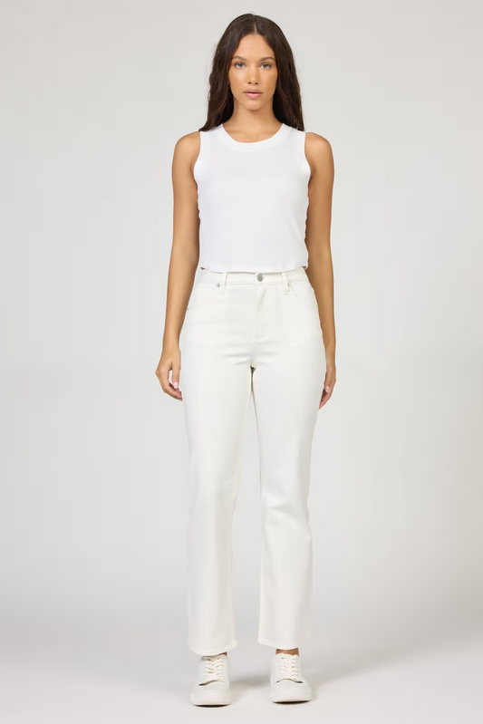 Woman wearing a white sleeveless top and pants on a plain background
