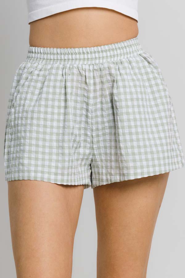 person wearing gingham checkered short in sage and white