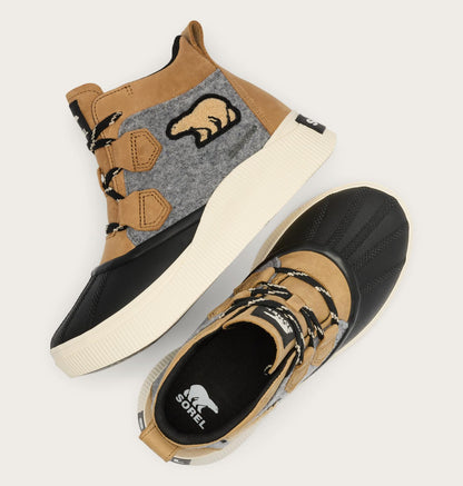 A pair of Sorel mid-top outdoor sneakers in tan, black, and gray, displayed on a light beige background. One shoe is shown from a top-down angle highlighting the side profile with its thick off-white sole, while the other is shown from a side angle highlighting the black toe cap and tan laces.