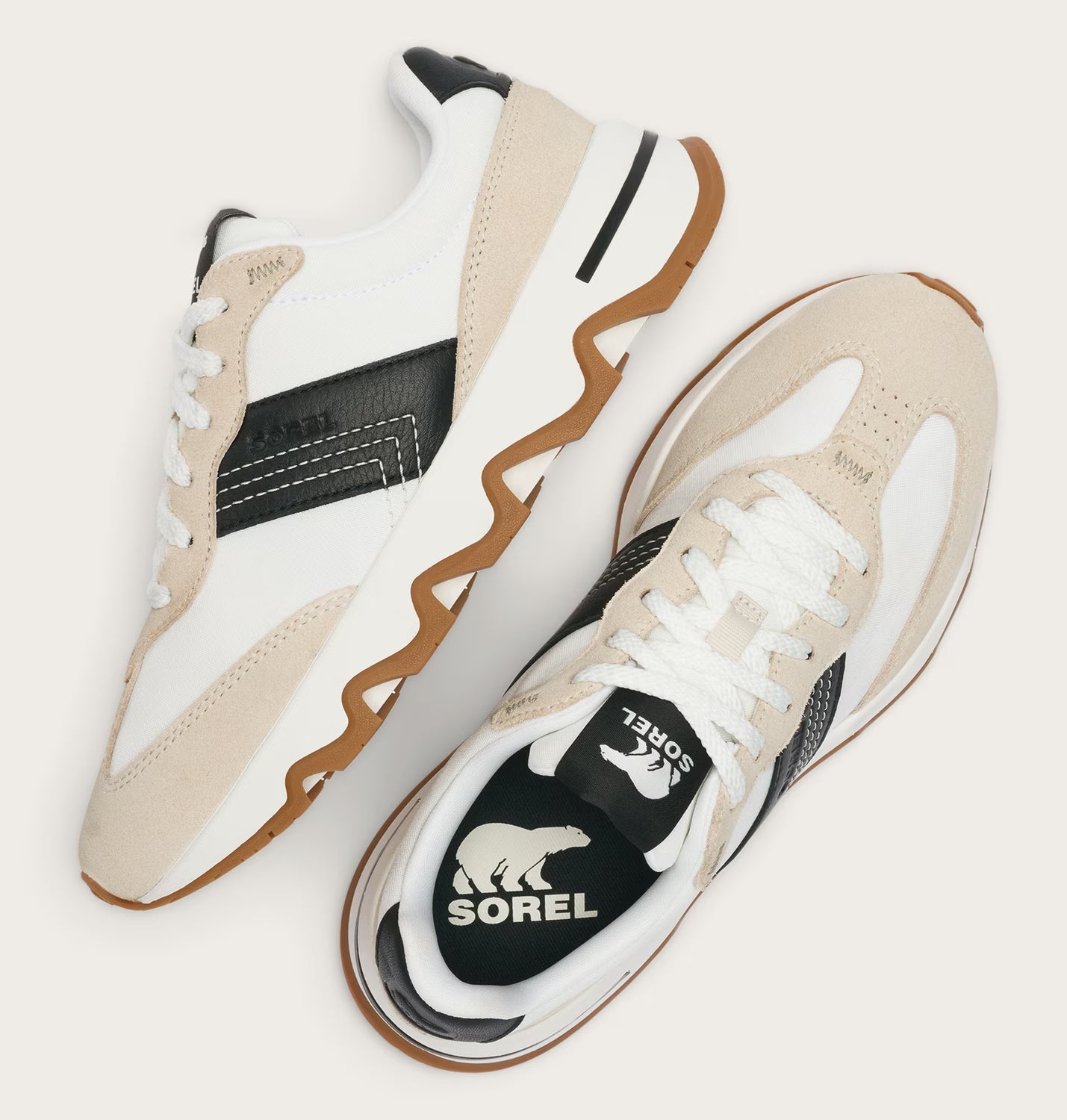 Pair of beige and white sneakers with visible Sorel logo on a light background