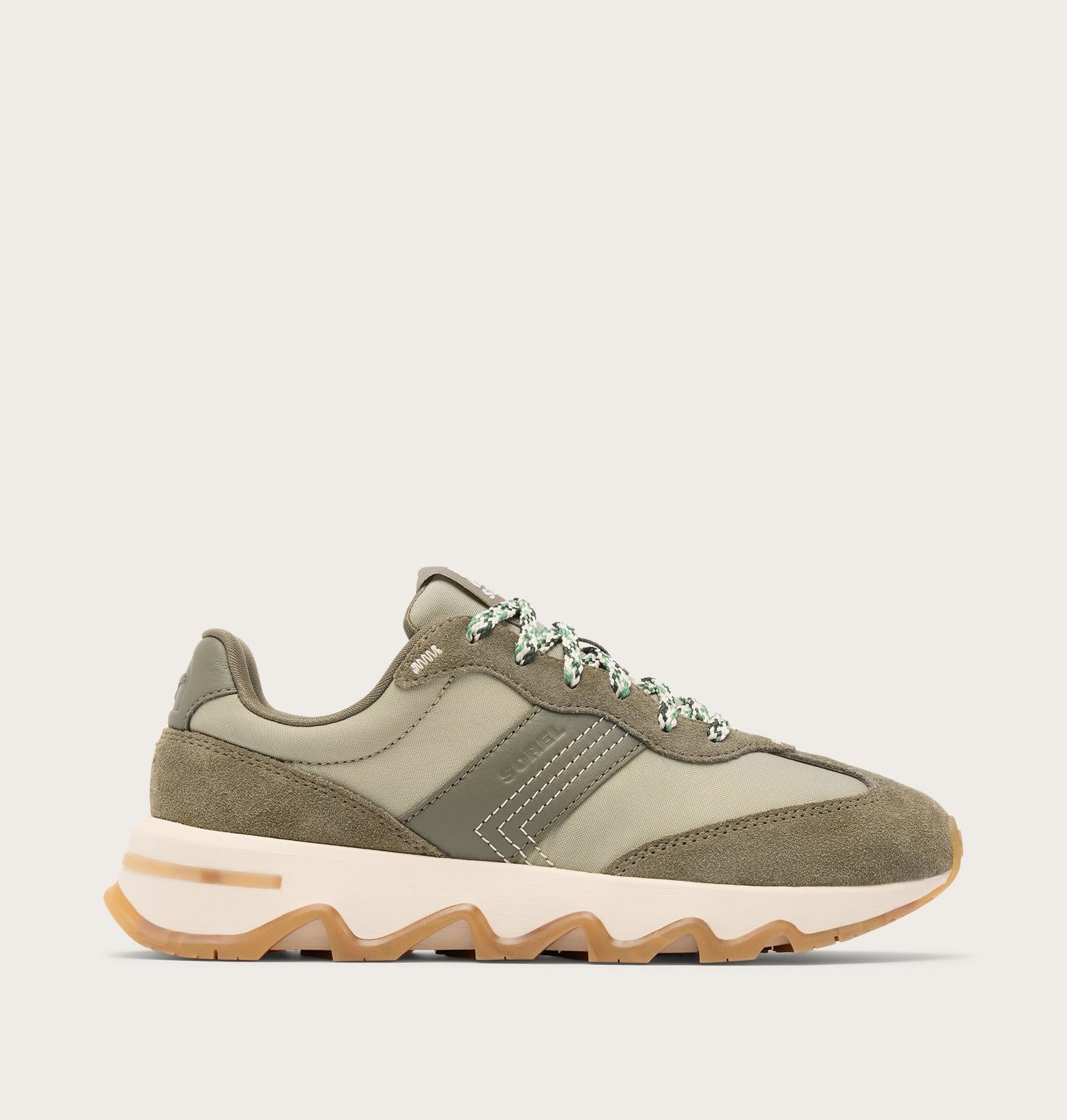 A low-top athletic sneaker in muted olive green and beige, featuring a chunky off-white midsole with a gum outsole, shown in a side profile on a light beige background.