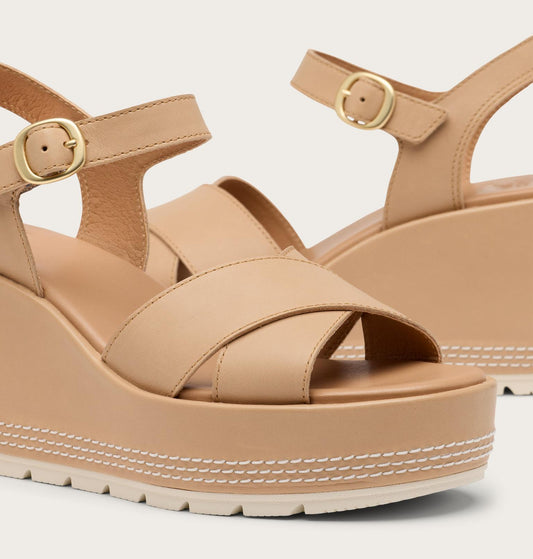 Beige platform sandals with gold buckles on a light gray background