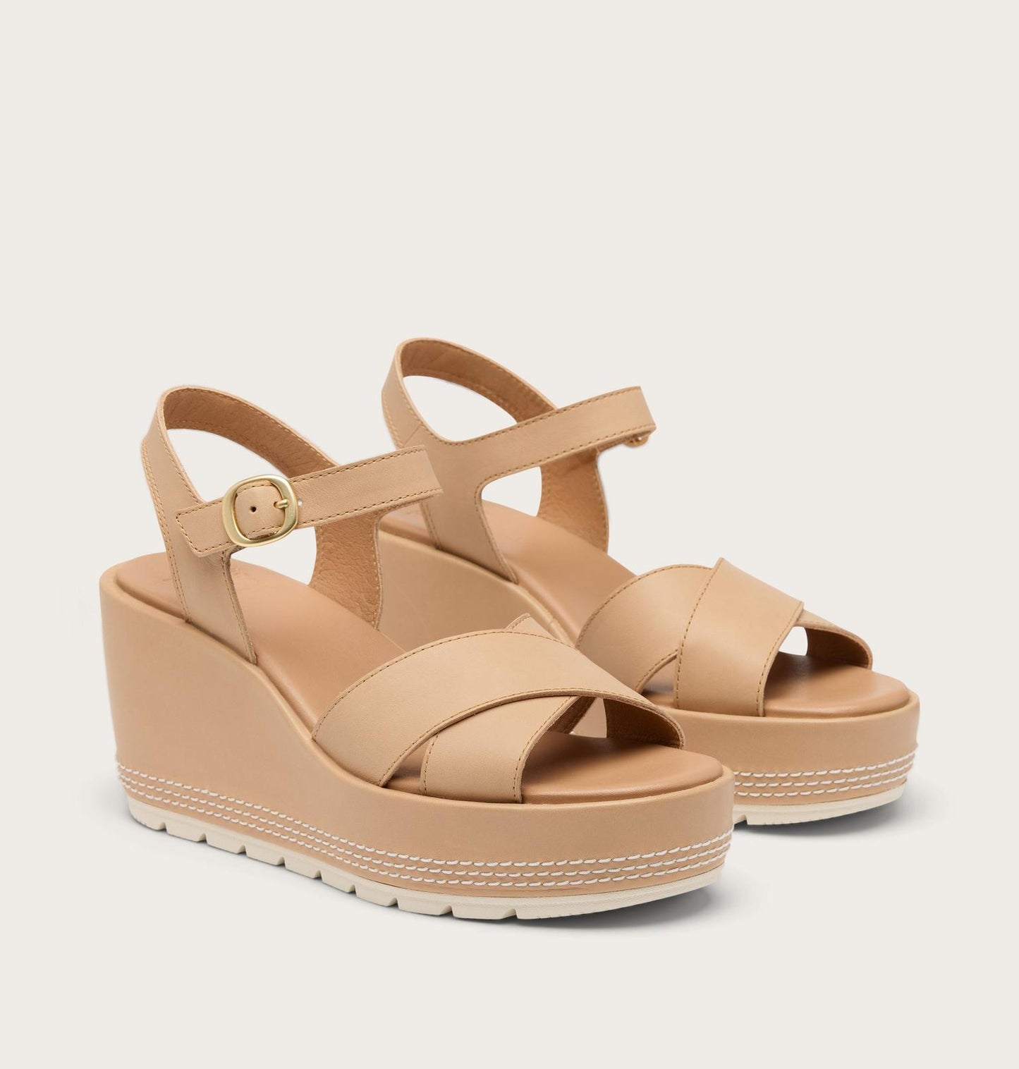 Beige wedge sandals on a light beige background