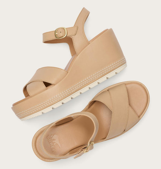 Pair of beige sandals with a buckle on a light gray background