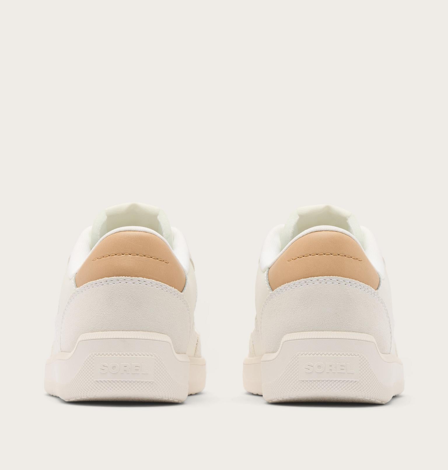 White sneakers with tan accents on a light gray background