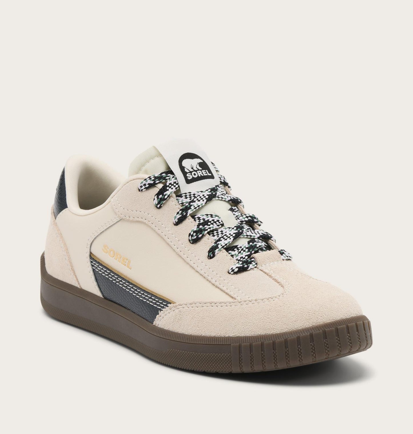 Beige sneaker with black and white laces on a light gray background