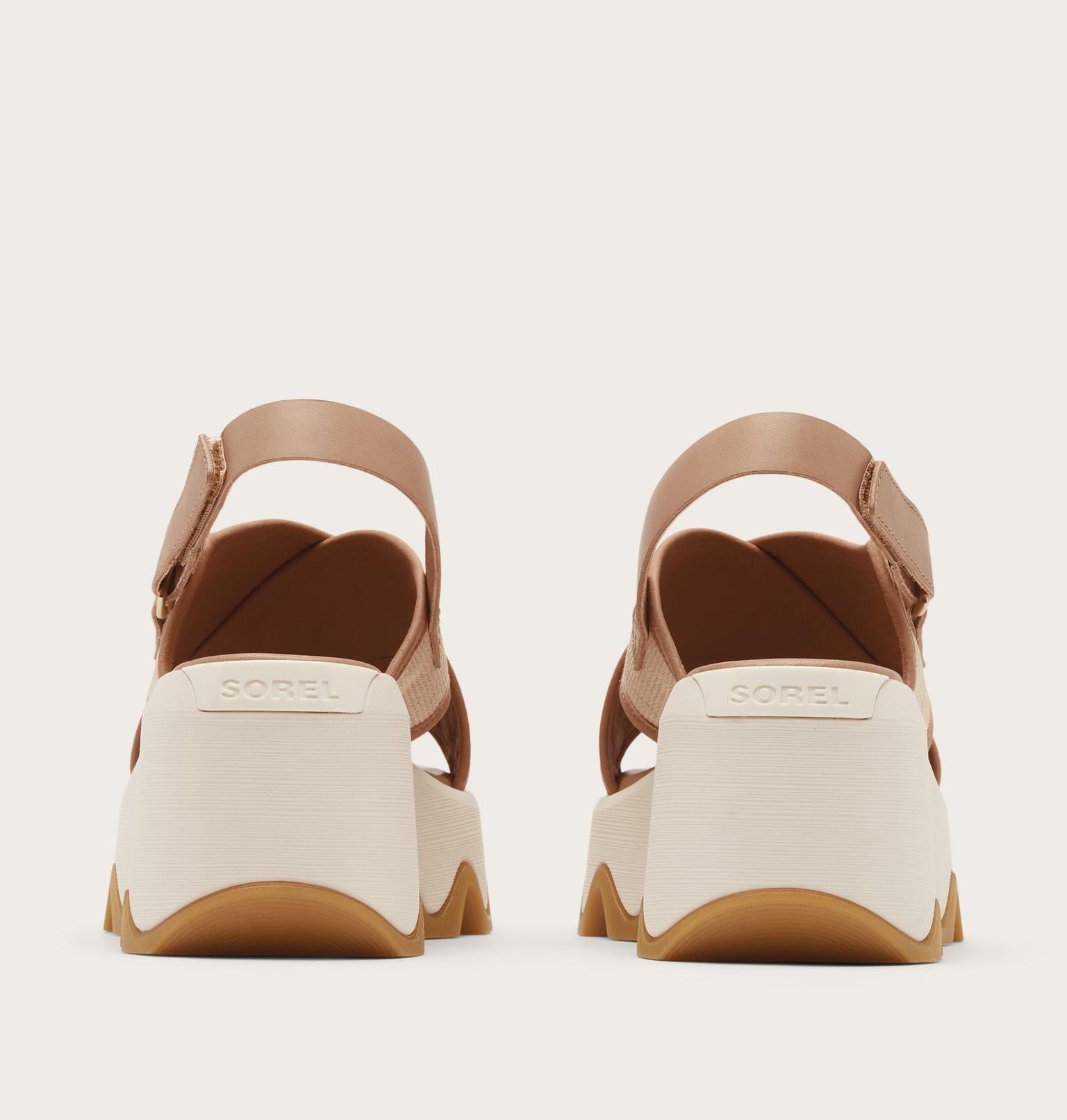 Pair of sandals with beige sole and brown straps on a light gray background