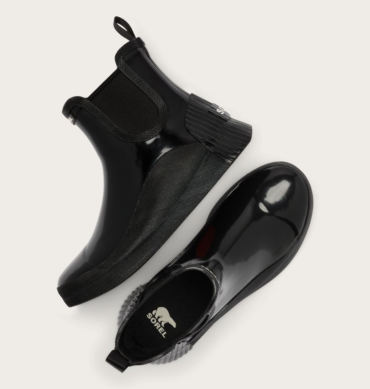 A pair of black rubber Chelsea-style boots with elastic side panels, shown from top and side angles on a light beige background. The brand name 'SALTS BODEL' is visible on the insole.
