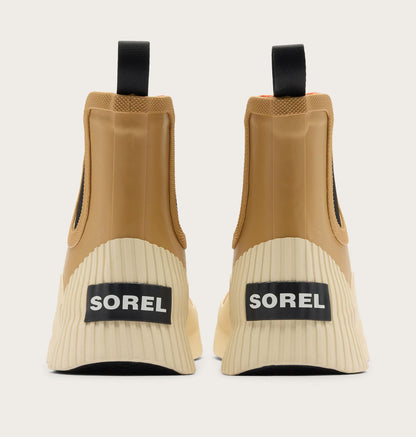 A pair of Sorel ankle boots shown from the back, featuring a tan upper, cream ribbed sole, and black pull tabs and logo patches.