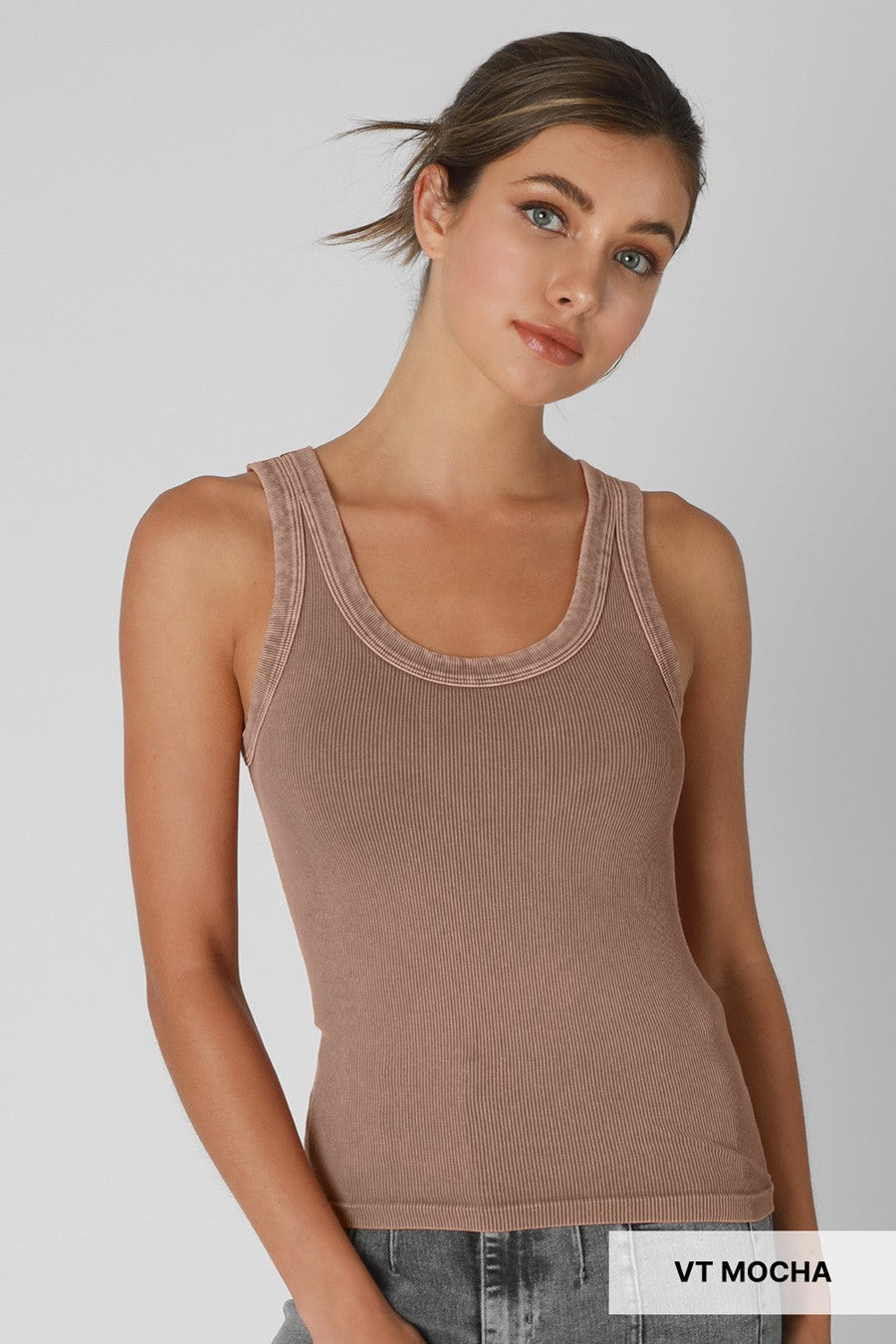 Woman wearing a brown tank top on a plain background