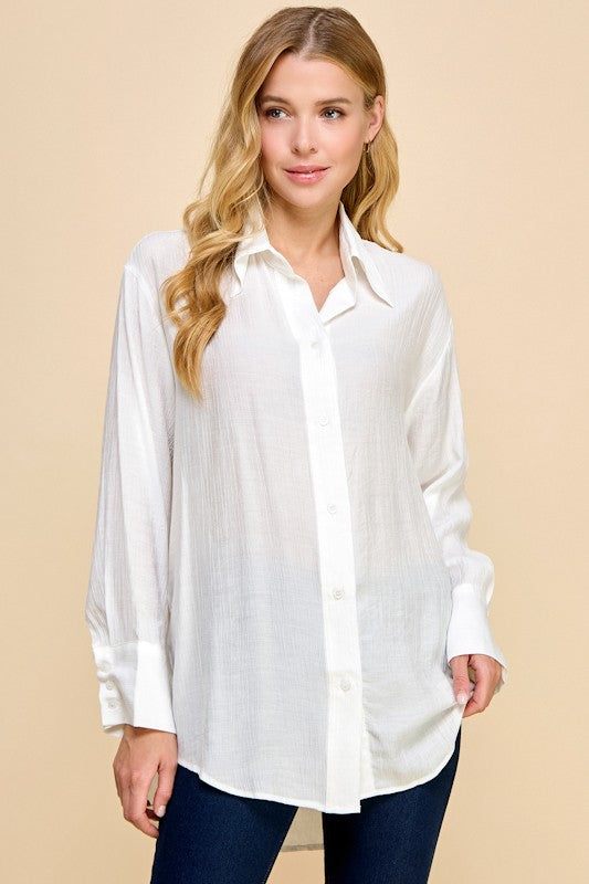 Woman wearing a white blouse against a beige background