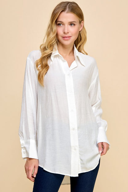 Woman wearing a white blouse against a beige background