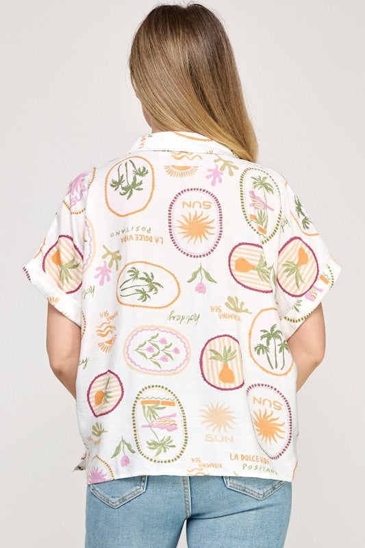 Person wearing a colorful patterned shirt with a plain background