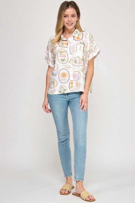 Woman wearing a patterned blouse and jeans on a white background