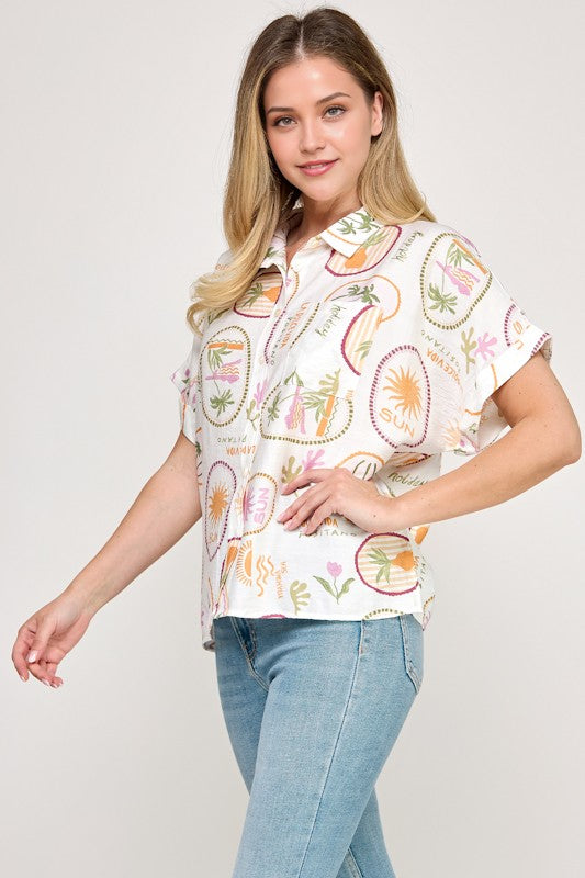 Woman wearing a patterned shirt and jeans on a plain background