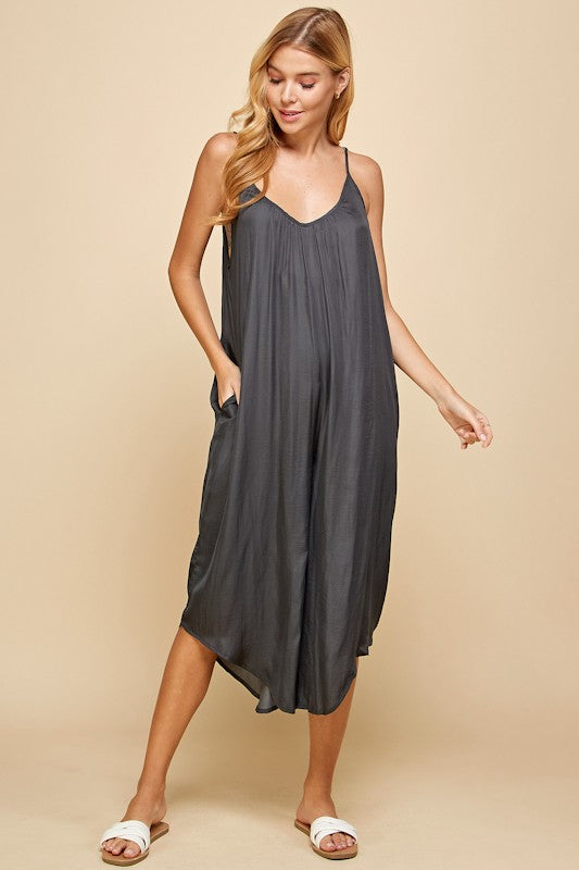 Woman wearing a dark gray dress against a beige background