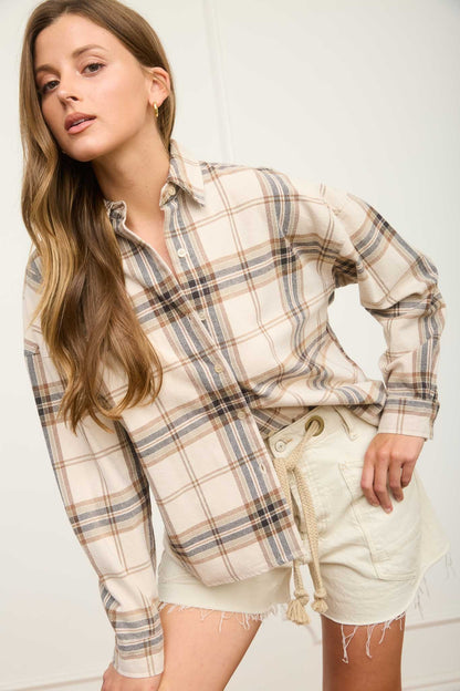 Woman wearing a plaid shirt and shorts on a white background