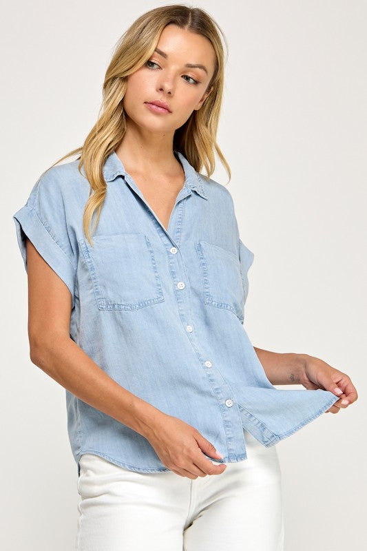 Woman wearing a light blue denim shirt on a white background
