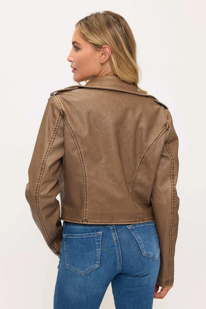 Woman wearing a brown leather jacket and blue jeans on a white background